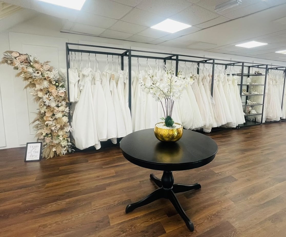 Leaf artificial orchids at Champagne & Lace bridal boutique, Louth – white orchid centrepiece by the wedding dress rails