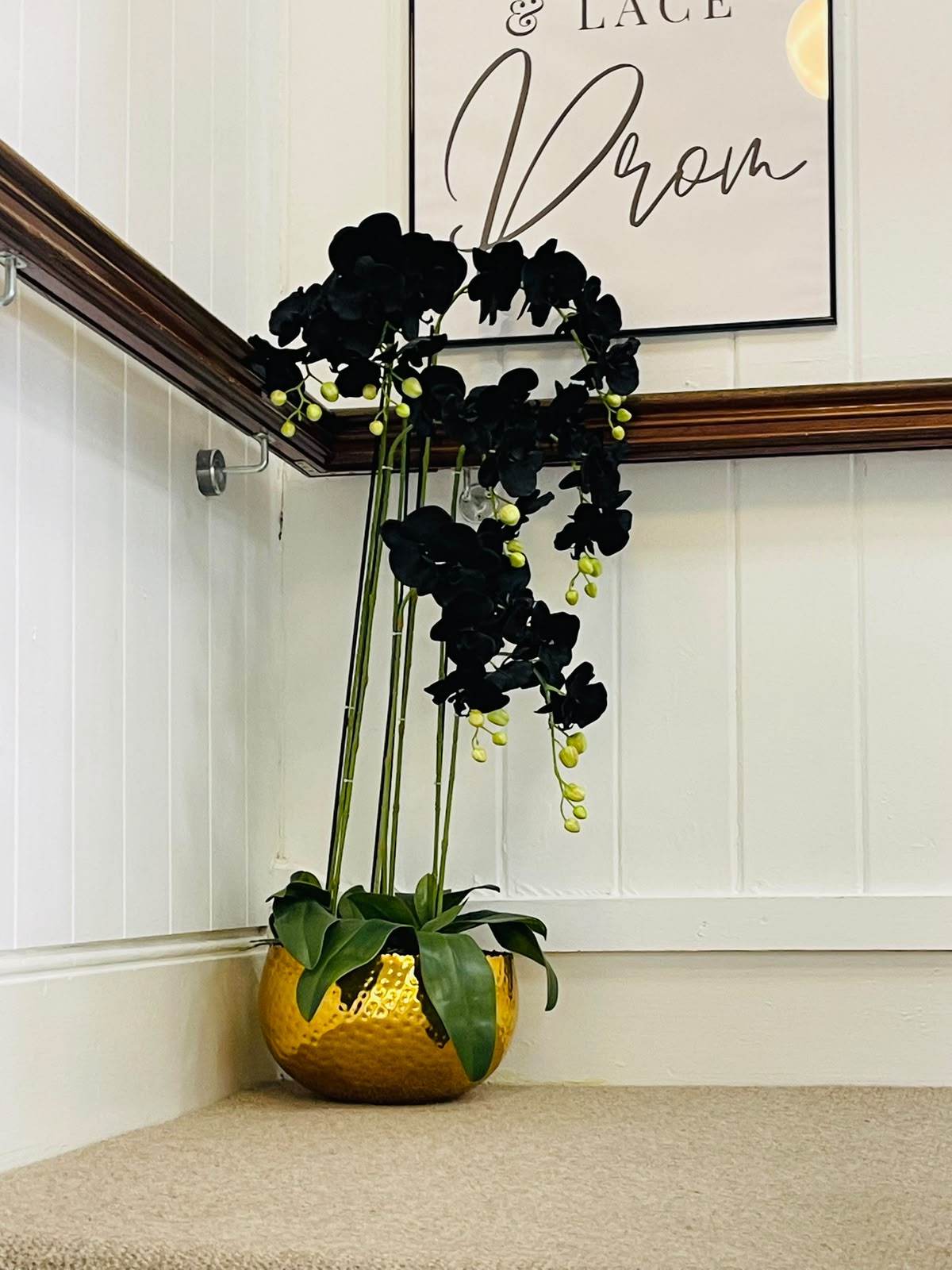 Leaf artificial orchids at Champagne & Lace bridal boutique, Louth – black orchid in gold bowl on the stairs